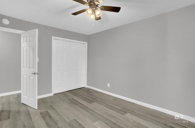 unfurnished bedroom with ceiling fan, a closet, and light wood-type flooring