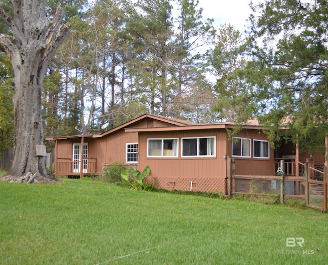 view of side of home with a yard and a deck