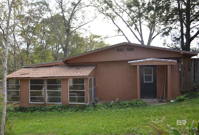 rear view of house featuring a yard