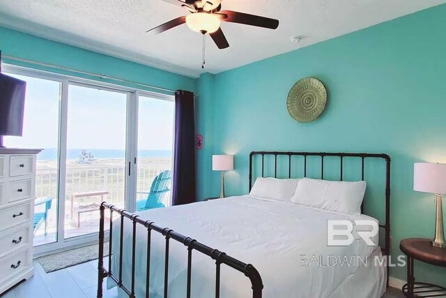 bedroom featuring a water view, multiple windows, ceiling fan, and access to outside