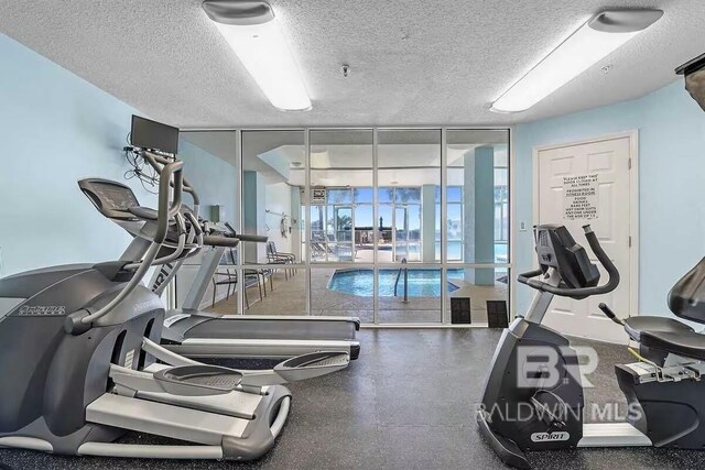 workout area featuring a textured ceiling and expansive windows