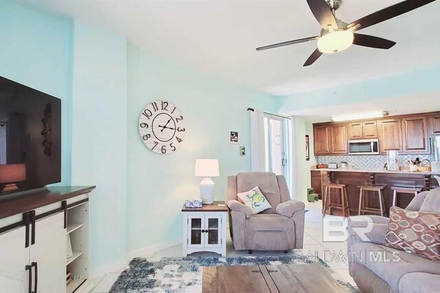 tiled living room with ceiling fan