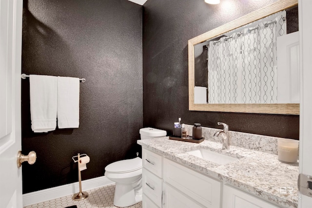 bathroom featuring vanity, tile patterned floors, and toilet