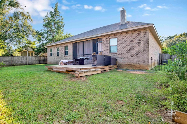 back of house featuring a yard and a deck