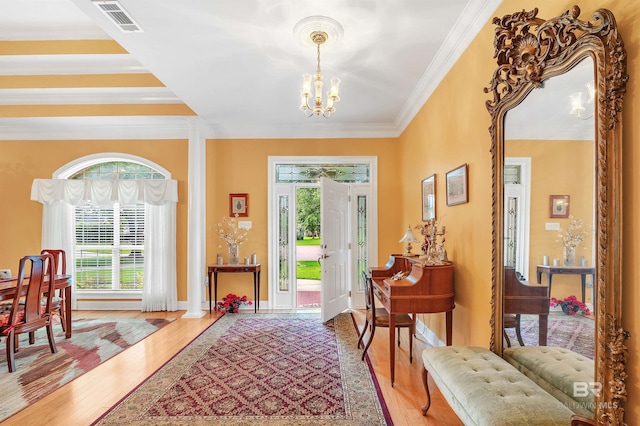 715 Village Dr, Gulf Shores, AL 36542 - entryway with a chandelier, plenty of natural light, wood finished floors, and ornamental molding