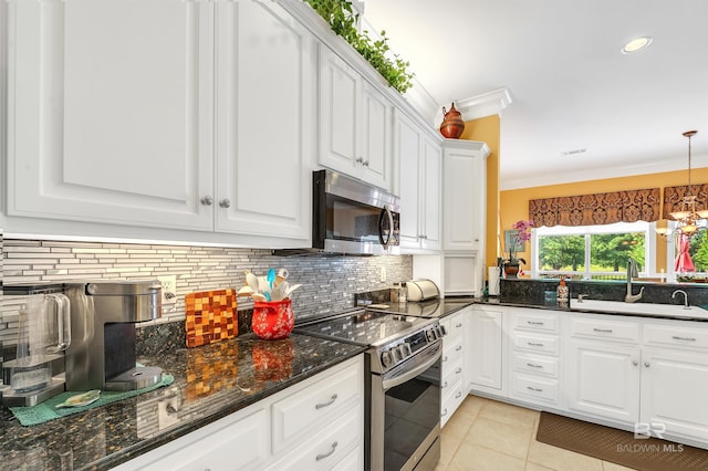 715 Village Dr, Gulf Shores, AL 36542 - kitchen with stainless steel appliances, tasteful backsplash, ornamental molding, white cabinetry, and light tile patterned floors
