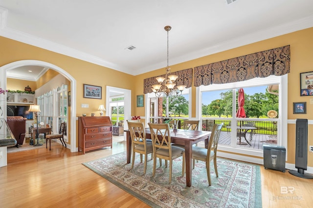 715 Village Dr, Gulf Shores, AL 36542 - dining space featuring arched walkways, crown molding, a chandelier, and light wood-style flooring