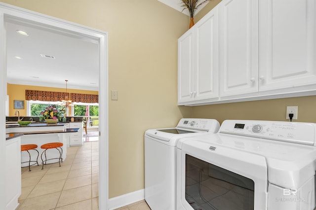715 Village Dr, Gulf Shores, AL 36542 - laundry room with washing machine and clothes dryer, cabinet space, a chandelier, and light tile patterned floors