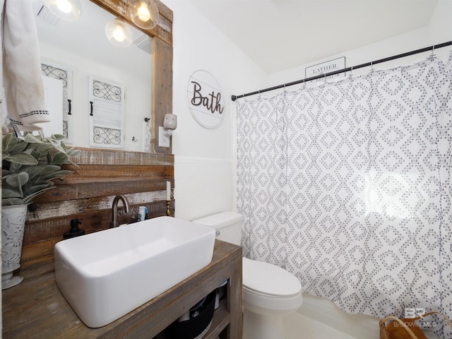 bathroom featuring a shower with curtain, vanity, and toilet