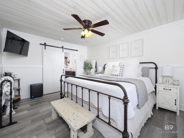 bedroom featuring dark wood-type flooring, wooden ceiling, a barn door, and ceiling fan