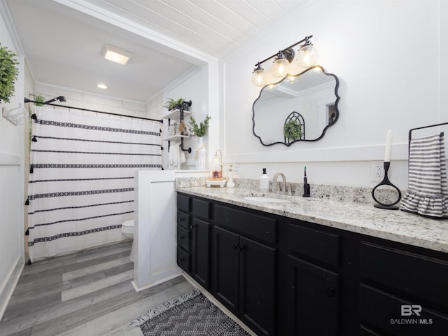 bathroom featuring hardwood / wood-style floors, curtained shower, ornamental molding, vanity, and toilet