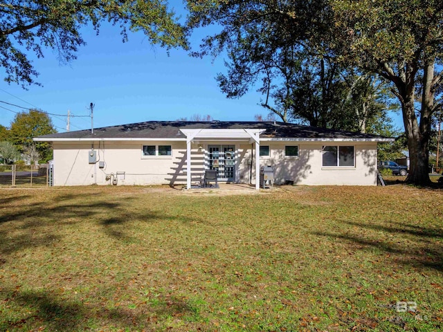 back of property with a yard and a patio area