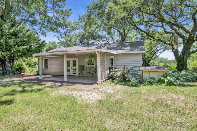 rear view of property with french doors, a yard, and a patio area