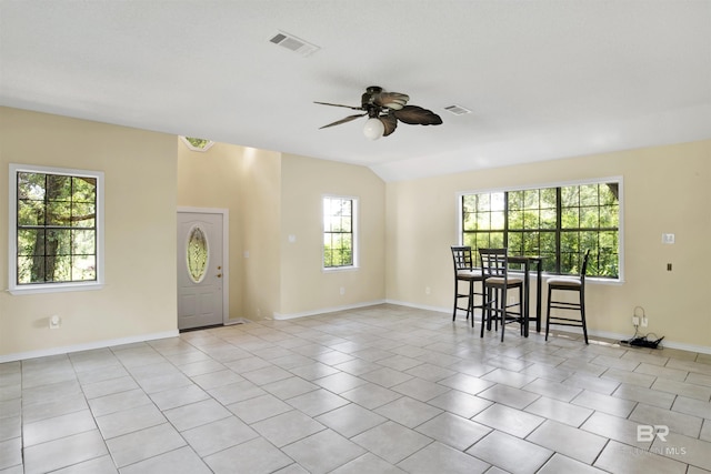 empty room featuring vaulted ceiling, ceiling fan, and light tile patterned flooring