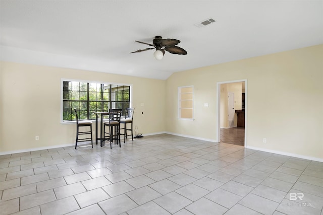 empty room featuring ceiling fan, light tile patterned floors, and lofted ceiling