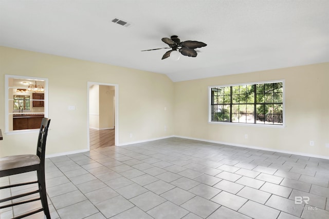 spare room featuring ceiling fan, light tile patterned floors, and vaulted ceiling