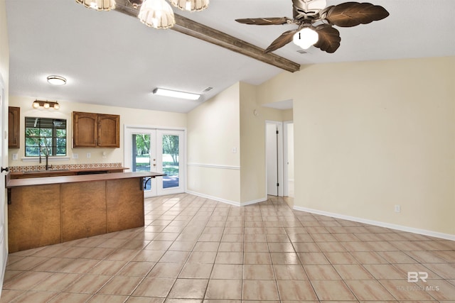 kitchen with lofted ceiling with beams, ceiling fan, sink, and french doors