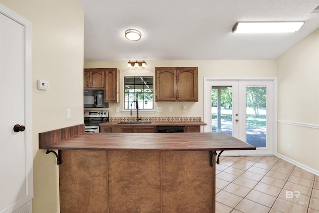 kitchen featuring kitchen peninsula, french doors, black appliances, and sink