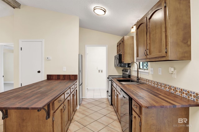 kitchen with light tile patterned floors, lofted ceiling with beams, stainless steel appliances, and sink