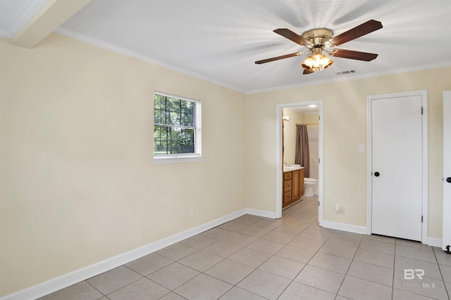 unfurnished bedroom featuring ceiling fan, crown molding, light tile patterned floors, and ensuite bathroom