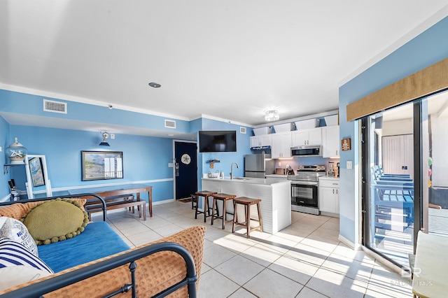 living room with light tile patterned floors, baseboards, and visible vents