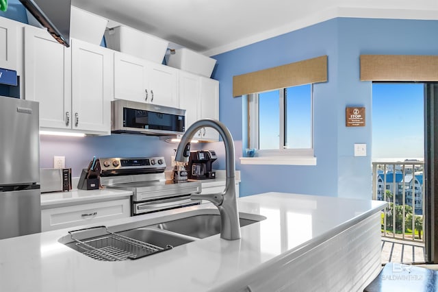 kitchen featuring a wealth of natural light, light countertops, white cabinets, and stainless steel appliances