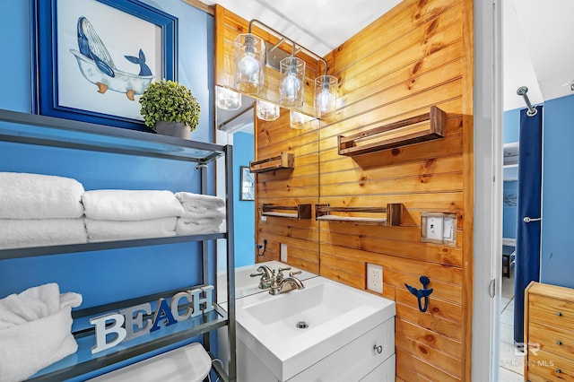 bathroom with vanity and wooden walls