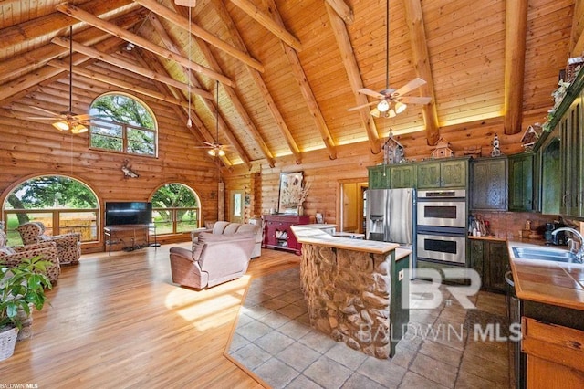 kitchen with appliances with stainless steel finishes, high vaulted ceiling, light wood-type flooring, and wood ceiling