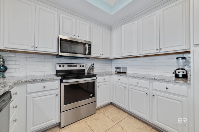 kitchen with light tile patterned flooring, white cabinets, backsplash, stainless steel appliances, and light stone countertops