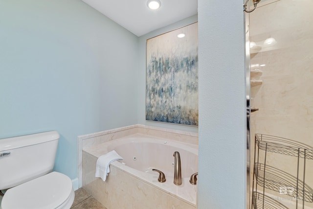 bathroom with a washtub, tile patterned flooring, and toilet