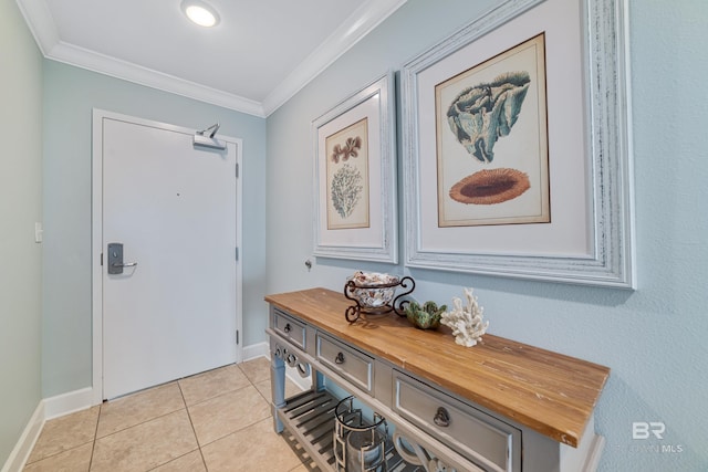 foyer entrance with ornamental molding and light tile patterned floors