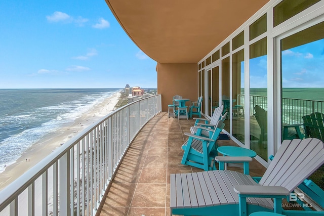 balcony featuring a beach view and a water view