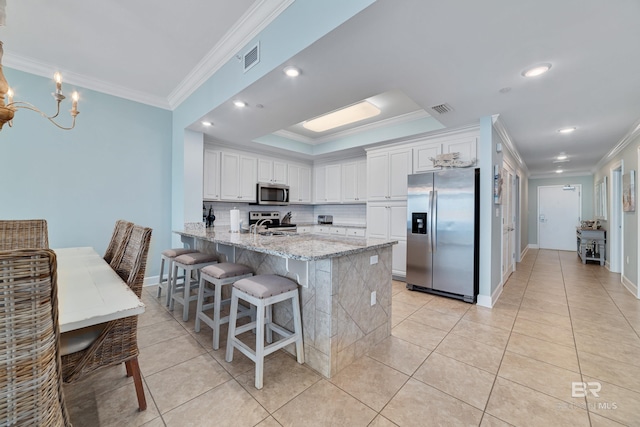 kitchen with white cabinetry, light stone countertops, crown molding, and stainless steel appliances