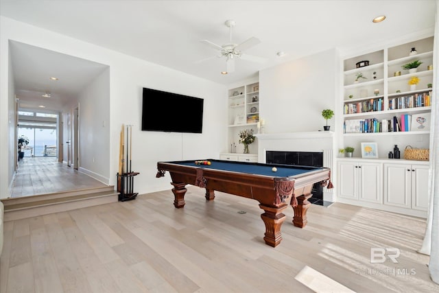 rec room with built in shelves, light hardwood / wood-style flooring, ceiling fan, and billiards