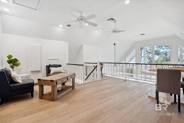 living area featuring light hardwood / wood-style flooring, vaulted ceiling, and ceiling fan