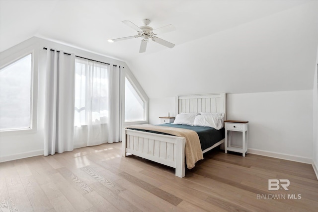 bedroom featuring multiple windows, ceiling fan, light hardwood / wood-style floors, and lofted ceiling