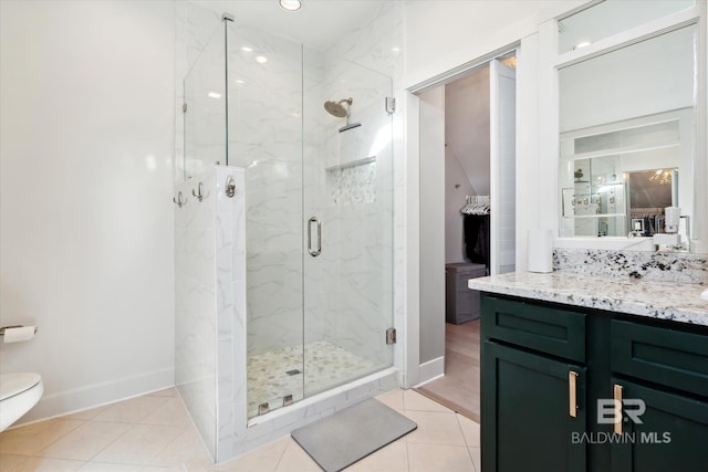 bathroom with tile patterned flooring, vanity, toilet, and a shower with shower door