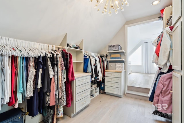 walk in closet with light wood-type flooring and vaulted ceiling