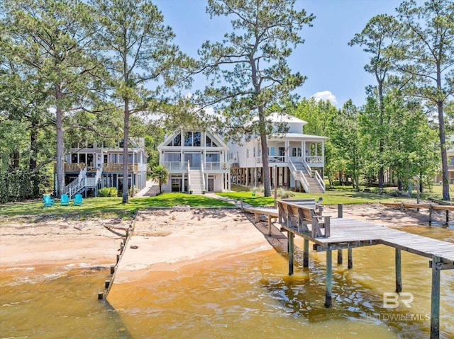 back of property with a sunroom and a deck with water view