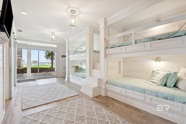 bedroom with access to exterior, light hardwood / wood-style flooring, and crown molding