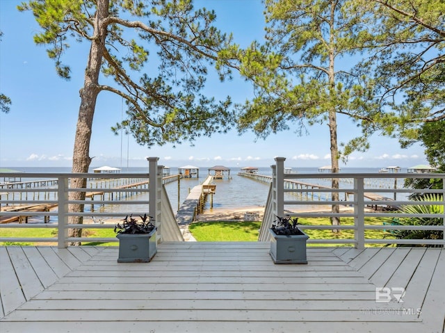 wooden deck with a boat dock and a water view