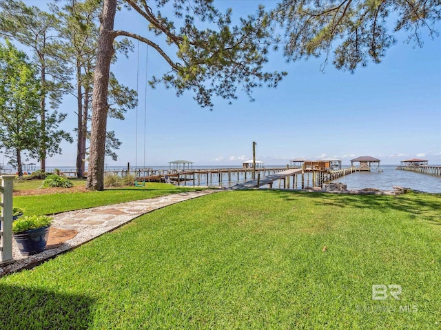 view of dock with a water view and a yard