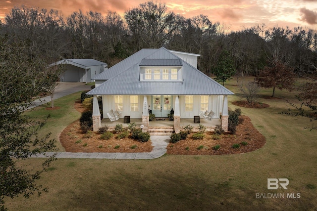 modern farmhouse style home with a garage, a yard, and covered porch