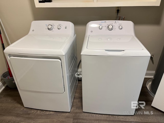 laundry area with separate washer and dryer and dark hardwood / wood-style flooring