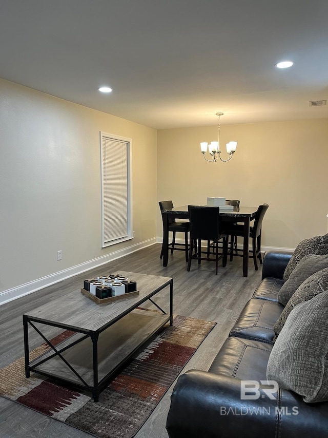 living room featuring dark wood-type flooring and an inviting chandelier