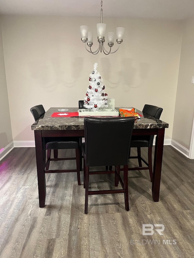 dining area with dark hardwood / wood-style flooring and a chandelier