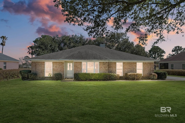 single story home featuring a front yard, brick siding, and a chimney