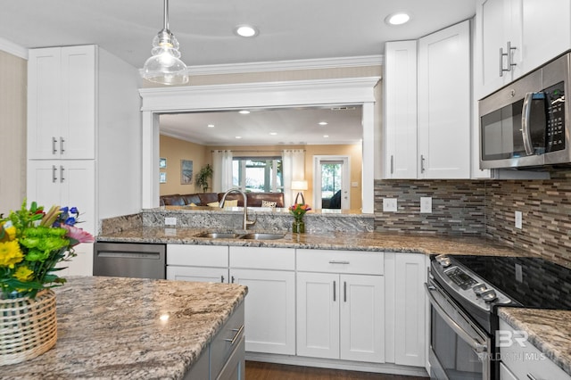 kitchen with stainless steel appliances, white cabinets, a sink, and tasteful backsplash