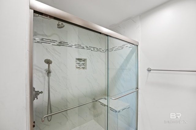 bathroom featuring a marble finish shower