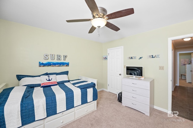 bedroom featuring a ceiling fan, light colored carpet, and baseboards